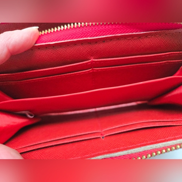 Red wallet with 2 zipper compartments and a wrist handle. - Picture 6 of 12